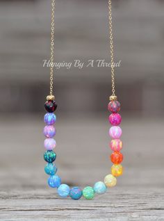 "A stunning new necklace made using opal gemstone beads and 14K gold filled. The necklace features 6mm beads in various colors. Each bead is a little work of art, and the colors are amazing! They range from red to light and dark pink, yellow, orange, blues, teals, purples, and more! Opal beads are 6mm in size, and strung onto 14K gold filled chain. Each end features a small gold plated bead. The opals are allowed to slide freely along the chain. Necklace closes with a 14K gold filled spring ring Rainbow Opal, Silver Jewelry Design, Opal Beads, Jewelry Inspo, Opal Necklace, Opal Gemstone, Gay Pride, Yellow Orange