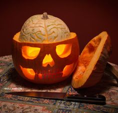 a pumpkin carved to look like a human skull with its head cut out and glowing inside