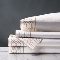 a stack of white sheets with gold designs on them