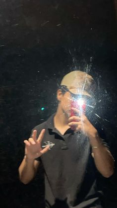 a man taking a selfie in front of a mirror with his hand up to the camera