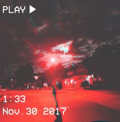 a blurry image of a person walking down the street at night with red lights