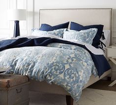 a bed with blue and white comforters in a bedroom