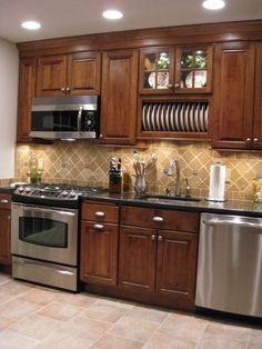 a kitchen with wooden cabinets and stainless steel appliances