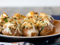 stuffed mushrooms covered in cheese and herbs on a plate