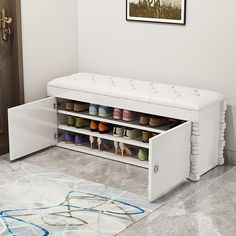 a white shoe bench with multiple pairs of shoes on it's bottom shelf next to a door