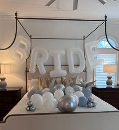 a bed with balloons that spell out the word bride