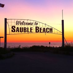 the welcome sign to sauble beach at sunset