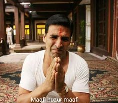 a man in white shirt sitting on top of a rug with his hands clasped together