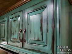 an old green cabinet with two handles on the top and bottom, painted teal