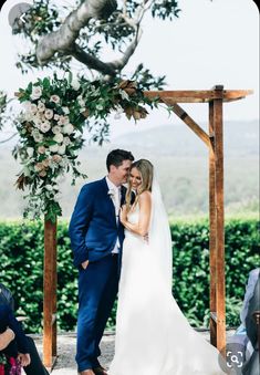 a bride and groom standing under an arch at their wedding