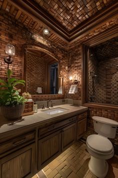 a bathroom with a toilet, sink and mirror in the corner next to a plant