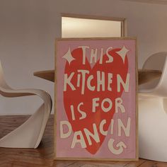 this kitchen is for dancing sign in front of a chair and table with chairs around it