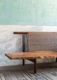 a wooden bench sitting in front of a wall with a stone floor and green walls