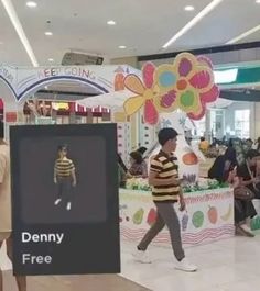 people are walking around in the mall and one person is holding a sign that says denny free