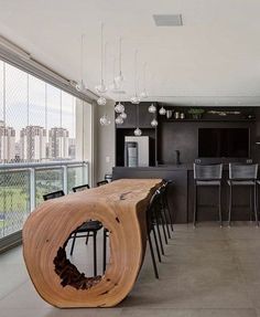 a large wooden table sitting in the middle of a living room next to a kitchen