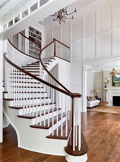 a spiral staircase in a white house with wood floors