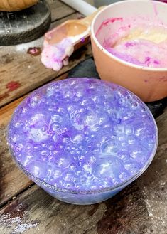 two bowls filled with different colored food sitting on top of a wooden table next to each other