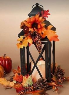 a candle is surrounded by autumn leaves and pumpkins