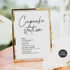 a cupcake station sign sitting on top of a wooden table