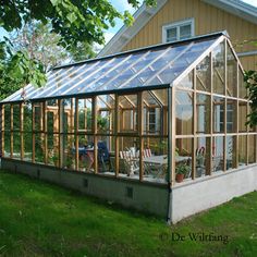 a house with a greenhouse in the yard