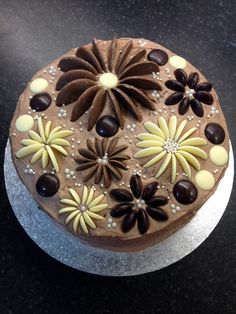 a chocolate cake decorated with flowers on top of a black countertop next to a knife