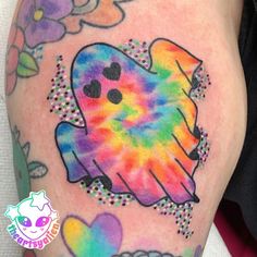 a colorful tattoo on the leg of a person with flowers and hearts around her arm