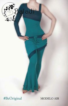 a woman in a green dress posing for the camera with her hands on her hips