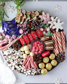 a platter filled with assorted holiday treats and candy canes on top of a white table