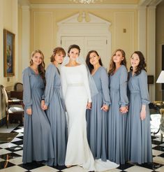 a group of women standing next to each other in front of a chandelier