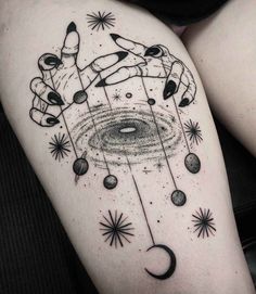 a woman's thigh with tattoos on her legs and an image of the planets