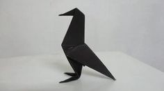 a black origami bird sitting on top of a table