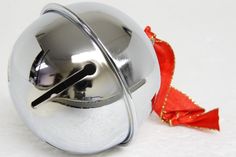 a silver bell with a red ribbon around it