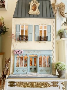 a doll house with blue shutters and windows