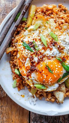 an egg and rice dish with chopsticks on the side