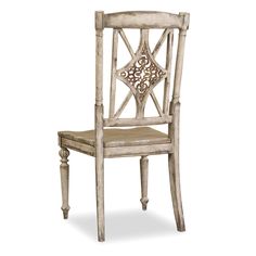 a white wooden chair with an ornate back and seat cushion on the side, against a white background