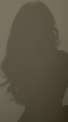 the silhouette of a woman's head against a foggy wall