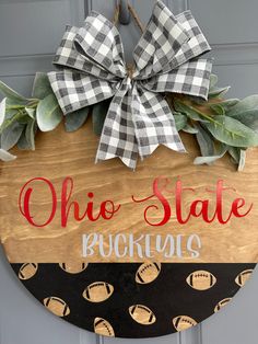 a wooden sign that says, ohio state buckeyes with footballs on it