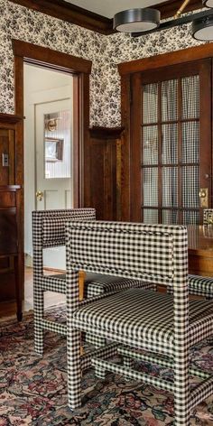 an old fashioned dining room with checkered upholstered chairs and rugs on the floor