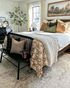 a bed sitting next to a window in a bedroom on top of a white rug