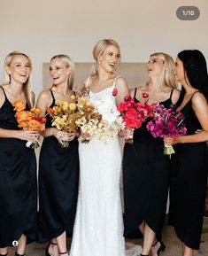 a group of women standing next to each other holding bouquets in their hands and laughing