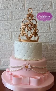 a pink and white cake with a gold crown on top