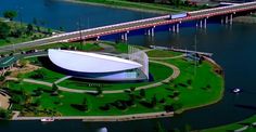 an aerial view of a bridge over a body of water next to a large white building