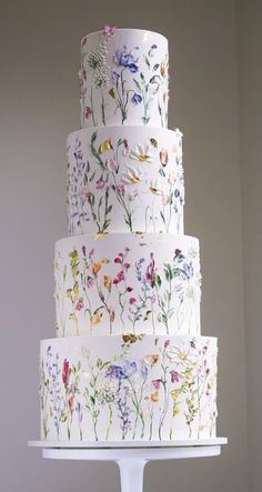 a multi - tiered cake with flowers painted on it