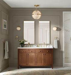 a bathroom with two sinks, mirrors and lights on the wall next to each other