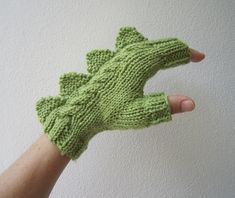 a hand that is wearing a green knitted mitt