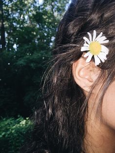 a close up of a person's ear with a flower in the middle of it