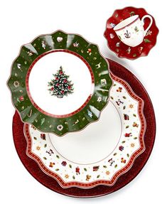 the christmas tree is on the plate next to the red saucer and cup set