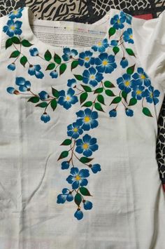 a white shirt with blue flowers on it