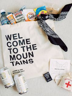 a tote bag that says welcome to the moun tauns with various items around it