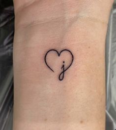 a small heart tattoo on the wrist